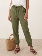 Woman wearing relaxed chic elastic ankles pants in casual stylish outfit outdoors