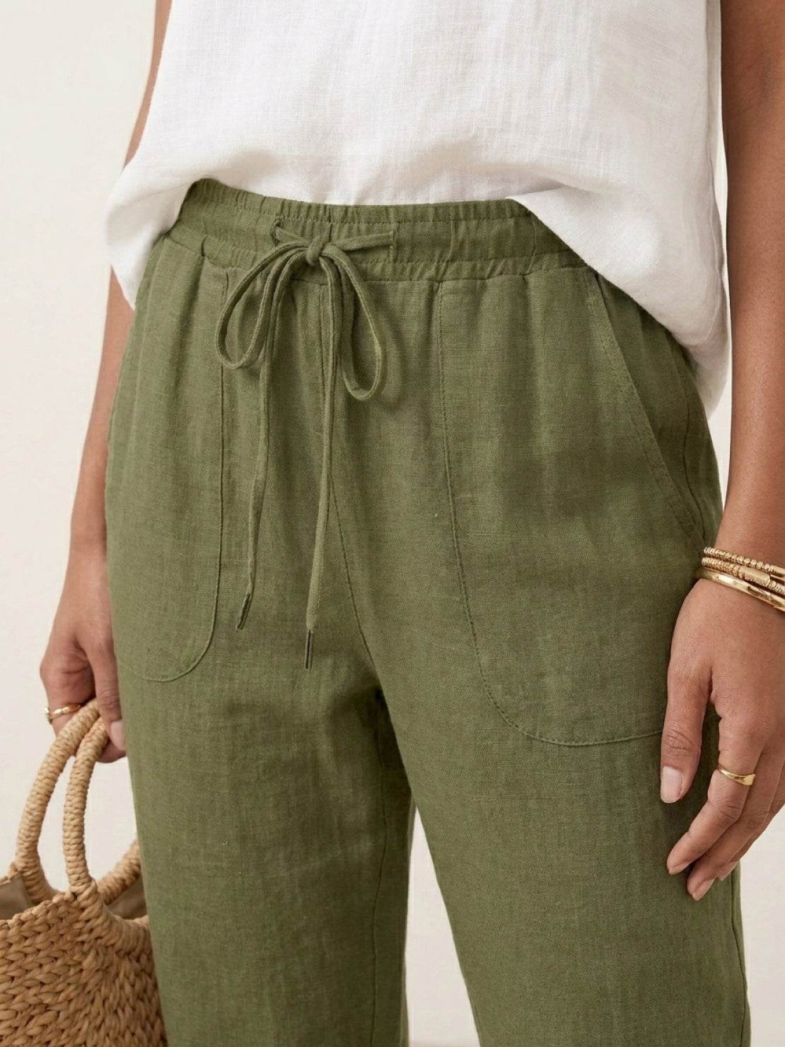 Woman wearing relaxed chic elastic ankles pants with a white top and heels in an outdoor setting