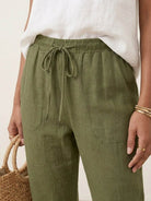 Woman wearing relaxed chic elastic ankles pants with a white top and heels in an outdoor setting