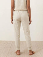 Woman wearing relaxed chic elastic ankles pants in casual stylish outfit standing outdoors