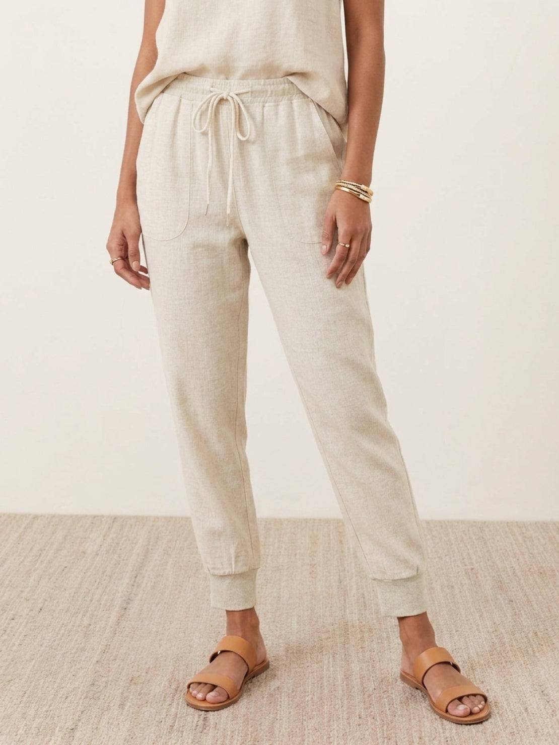 Woman wearing relaxed chic elastic ankles pants styled casually with sneakers and a jacket