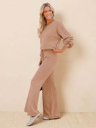 Woman wearing beige round neck loose fit cozy two-piece set with wide-leg pants against a neutral background