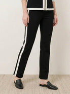 Woman wearing sleek contrast zip two-piece outfit in black and camel colors