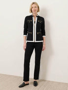 Woman wearing sleek contrast zip two-piece outfit standing against white background