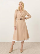 Woman wearing water-repellent A-line hooded raincoat with belt outdoors
