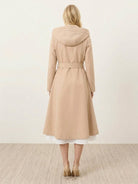 Water-repellent A-line hooded raincoat with feminine fit and matching belt, designed for stylish weather protection