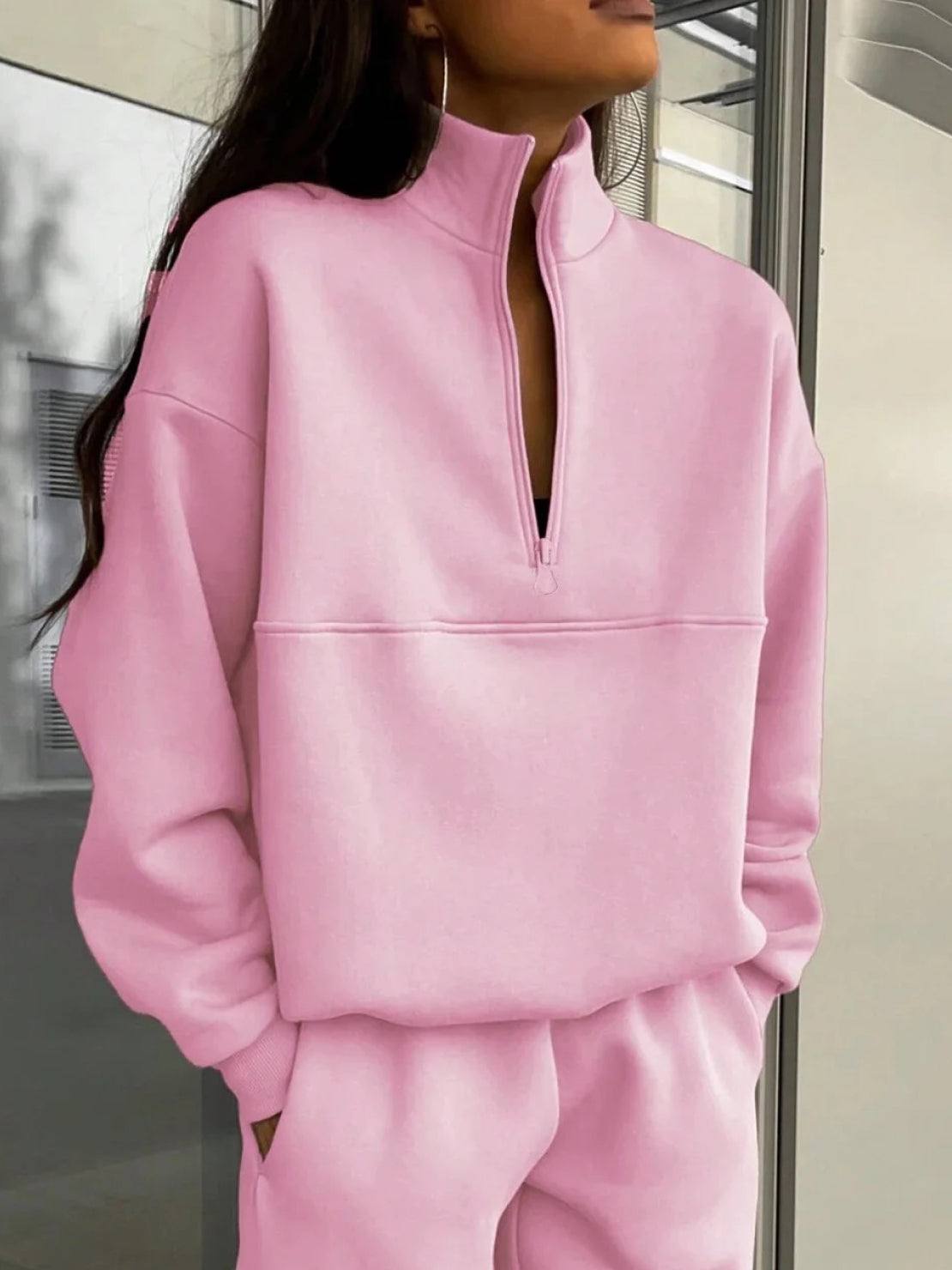 Woman wearing cotton-blended two-piece tracksuit with high collar and deep zipper outdoors