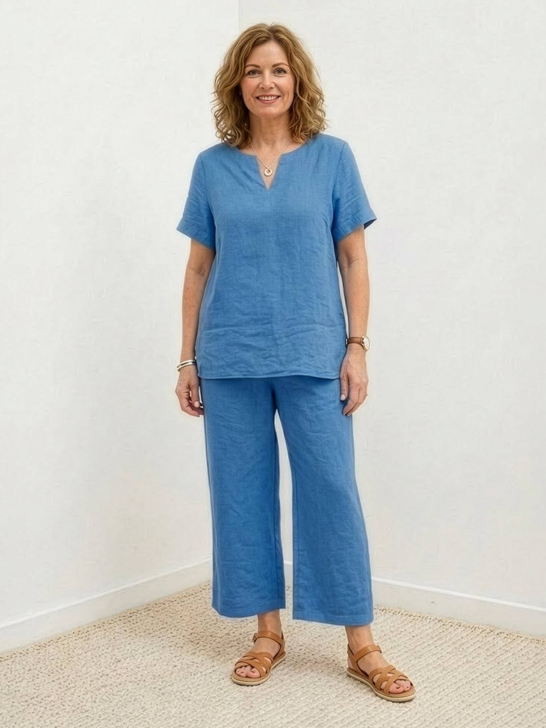 Woman wearing breezy cotton blend two-piece summer set with short-sleeved shirt and elastic waist pants