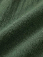 Woman wearing capped-sleeve voluminous pleated midi dress with flowing skirt and pockets