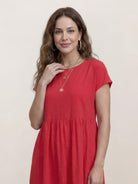 Woman wearing a capped-sleeve voluminous pleated midi dress with pockets and flowing silhouette