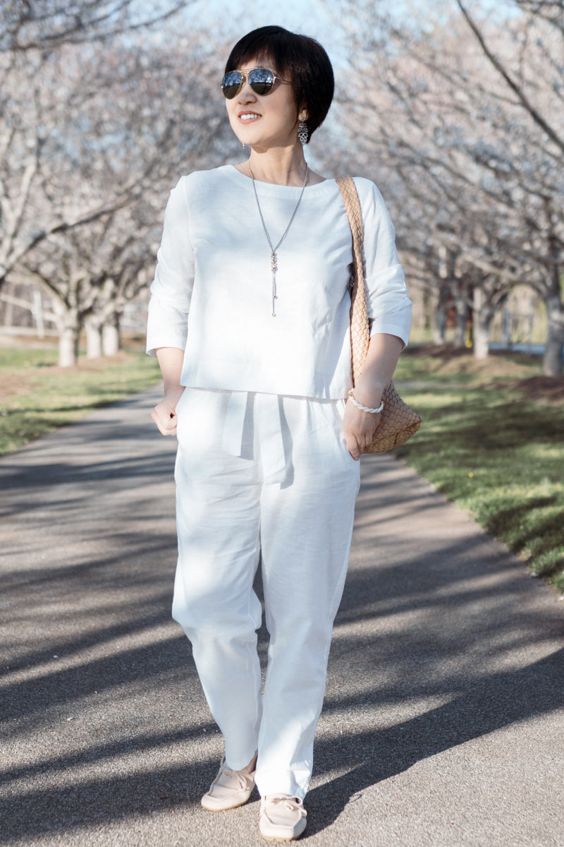 Woman wearing relaxed cotton-linen monochrome capsule outfit with longline top and wide-leg pants outdoors