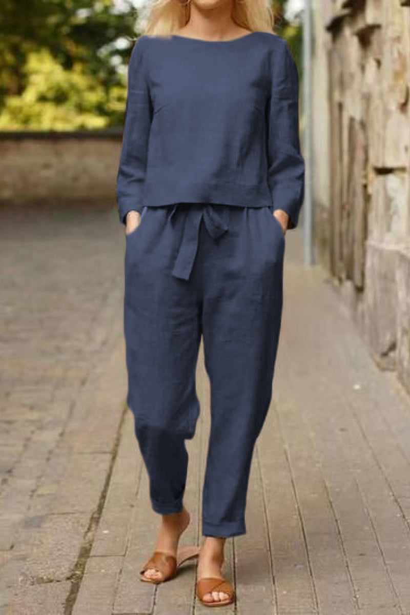 Woman wearing navy blue cotton-linen monochrome capsule outfit with relaxed longline top and wide-leg pants walking outdoors