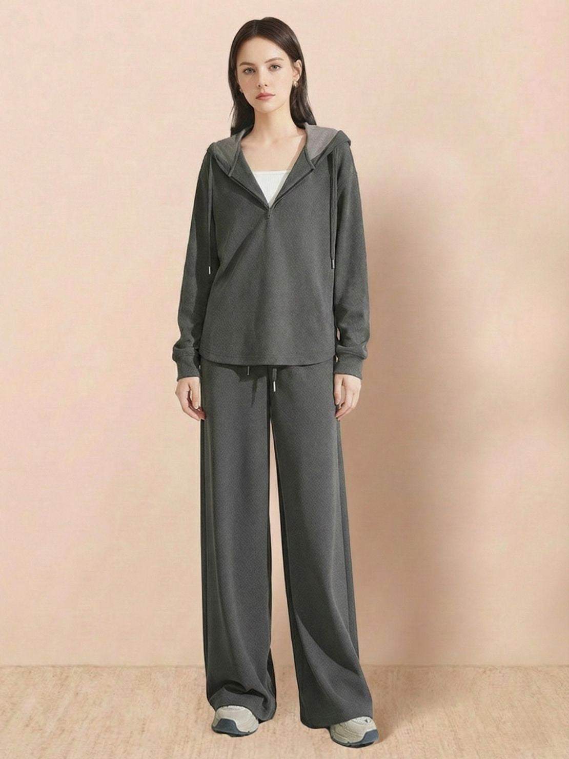 Woman wearing gray Lyocell-blend hooded set with wide-leg pants and hooded top.