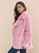 Woman wearing pink open front oversized faux fur jacket with draped collar and mid-hip length