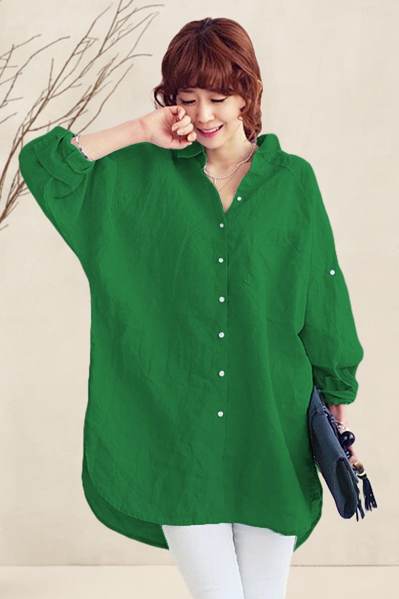 Woman wearing oversized green linen shirt with white buttons and holding a clutch, styled casually with white pants