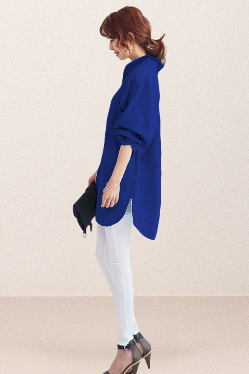 Woman wearing oversized linen shirt in blue with loose sleeves and flowing hemline paired with white pants and heels