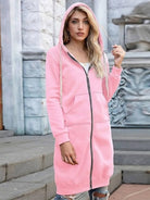 Woman wearing oversized long zip sweatshirt hoodie in pink with front pockets and hood