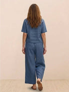 Woman wearing blue loose fit co-ord set with short sleeves and wide-leg trousers back view