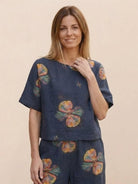 Woman wearing a floral print loose fit co-ord set with wide short sleeves and wide-leg bottoms