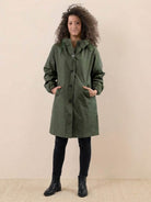 Woman wearing green oversized Rain Couture Windbreaker jacket with hood and pockets
